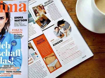 Magazinbeitrag über Ein schöner Fleck Erde mit nachhaltiger Unterwäsche im Lifestyle-Magazin neben einer Kaffeetasse – Bericht über faire Mode mit Bergmotiv-Design