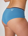 Rückansicht einer blauen Damen-Hipster-Unterhose mit dunklem Bund und dem weißen Aufdruck „EIN SCHÖNER FLECK ERDE.“ unterhalb der Bundnaht.