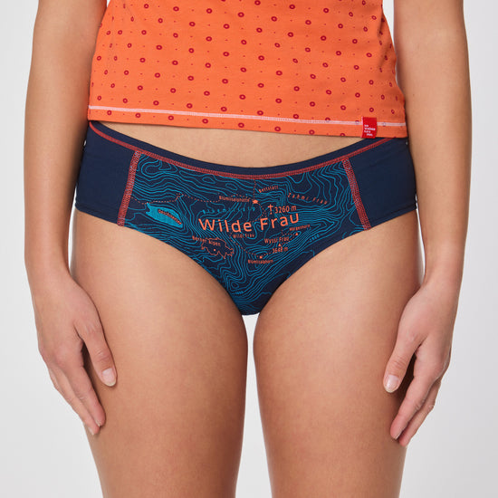 Frau in orangefarbenem Top und dunkelblauer Hipster Unterhose mit Aufdruck ‚Wilde Frau