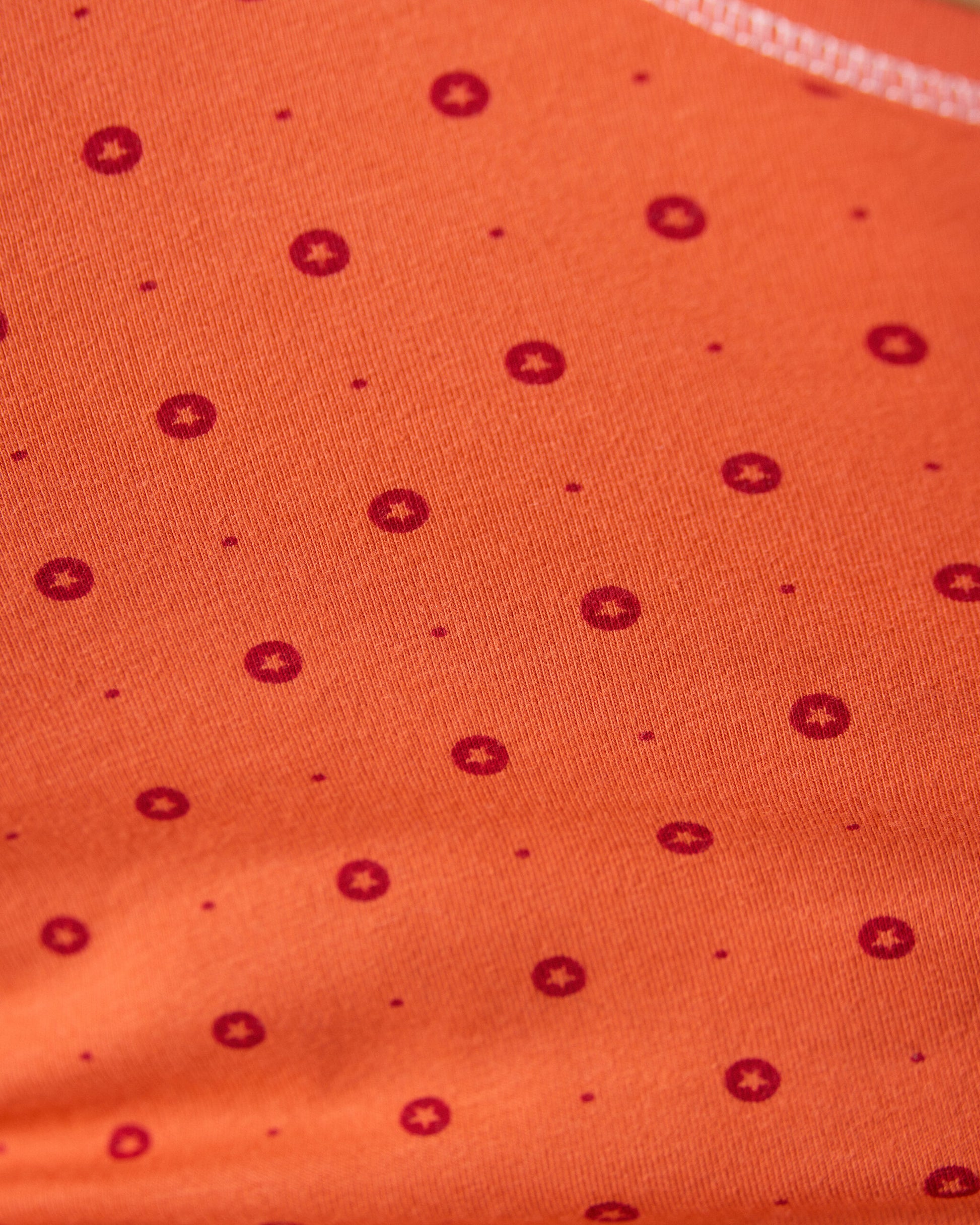 Detailaufnahme orangefarbener Stoff mit rotem Punktmuster