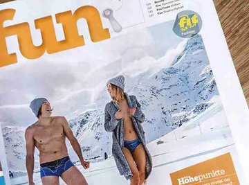 Zeitschriftenseite mit Foto eines Mannes und einer Frau in Unterwäsche von Ein schöner Fleck Erde vor winterlicher Bergkulisse – alpine Modekampagne im Magazin „Fit for Fashion“.