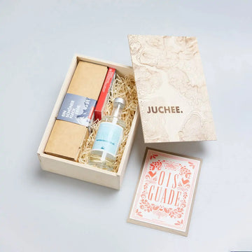 Geschenkbox „JUCHEE.“ von Ein schöner Fleck Erde mit Hochalpin Dry Gin, nachhaltig verpackter Unterwäsche und Grußkarte „Ois Guade“ – stilvolles Geschenkset im alpinen Design.