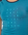 Nahaufnahme eines blauen T-Shirts mit türkisfarbenem Aufdruck ‚Kopf frei – hier spielt das Leben‘.