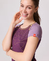 Frau lächelt in Nahaufnahme und trägt violettes Funktionsshirt mit gelben Linien und kurzem Ärmel von Ein schöner Fleck Erde, Studioaufnahme
