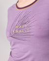 Detailaufnahme eines lilafarbenen T-Shirts mit gelbem Schriftzug Wald knallt und Kiefernmotiv von Ein schöner Fleck Erde