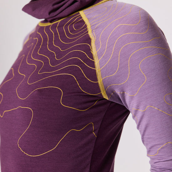 Detailaufnahme eines violetten Langarmshirts mit lilafarbenen Ärmeln und gelben Linienmustern von Ein schöner Fleck Erde