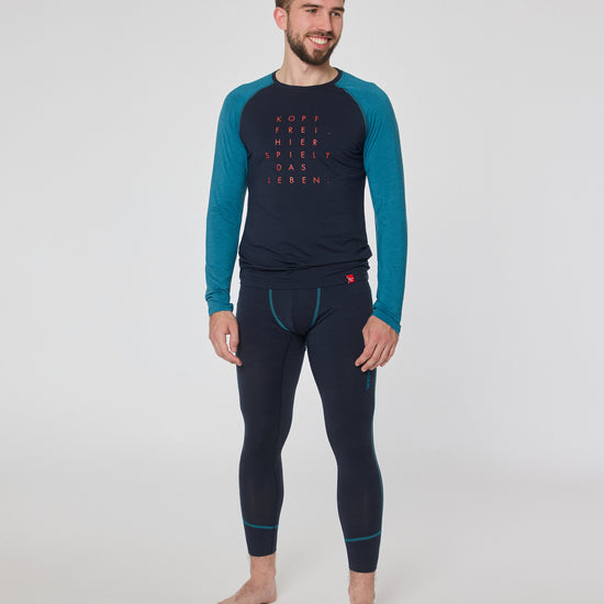 Mann trägt dunkelblaue Funktionsleggings und langärmliges Shirt mit blauen Ärmeln und rotem Schriftzug ‚Kopf frei, hier spielt das Leben‘ von Ein schöner Fleck Erde.