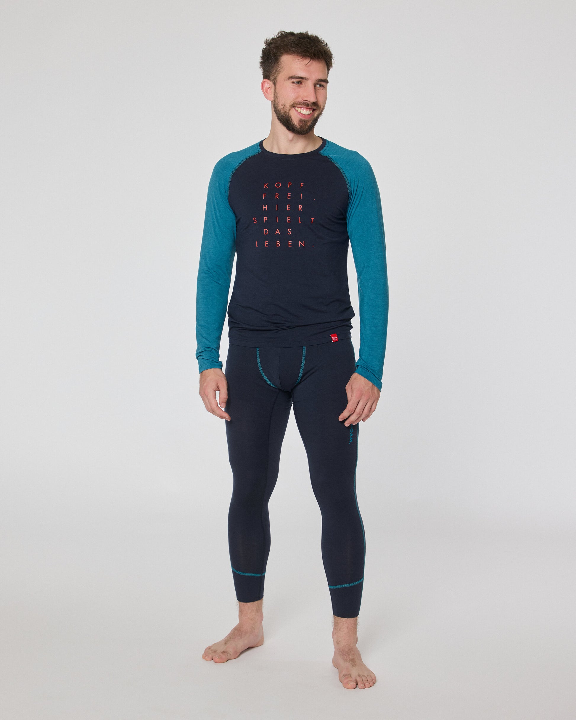 Mann trägt dunkelblaue Funktionsleggings und langärmliges Shirt mit blauen Ärmeln und rotem Schriftzug ‚Kopf frei, hier spielt das Leben‘ von Ein schöner Fleck Erde.